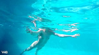 Captivating young curly chick Heidi is swimming in the pool
