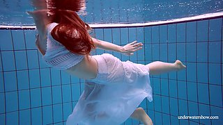 Stunning red haired porn model Marketa shows striptease under the water